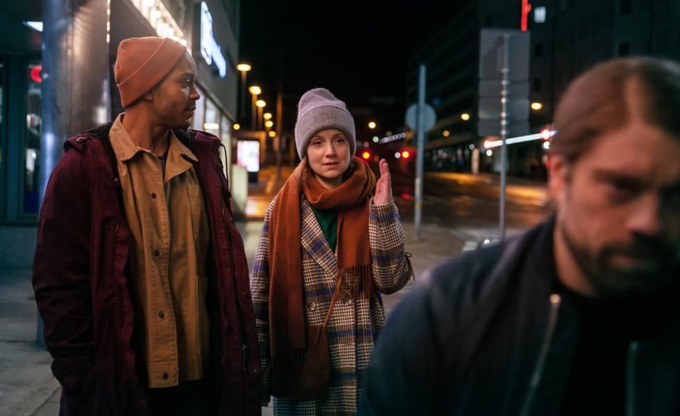 Nuori nainen ja kaksi miestä kulkevat iltaisella Turun kadulla.